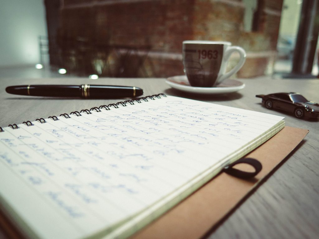 Notebook, pen and a cup of coffee